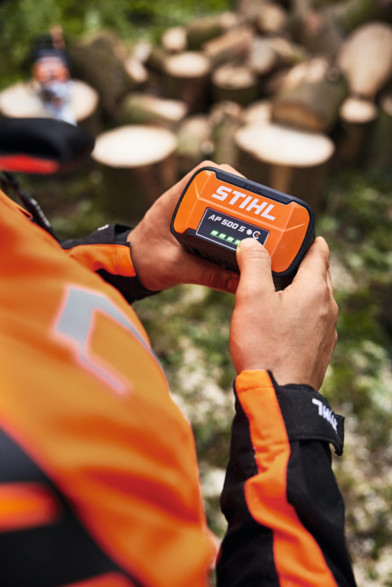 Nærbilde av en person som skjærer gjennom en trestamme med STIHL MSA 300 batteridrevet motorsag