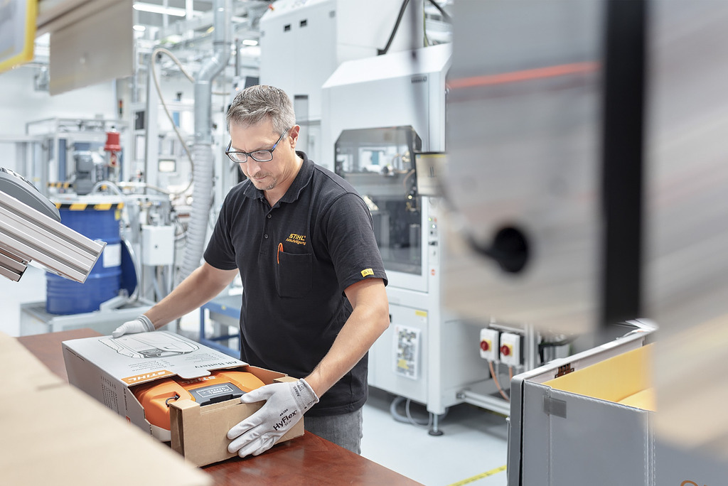 En medarbeider ved batteriavdelingen pakker et STIHL batteriverktøy i en pappeske 