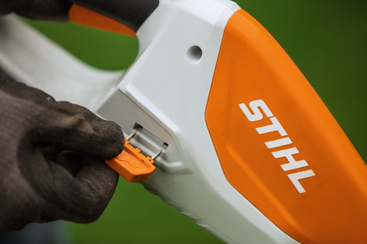 Nærbilde av aktiveringsnøkkelen til en STIHL batteridrevet gresstrimmer med integrert batteri