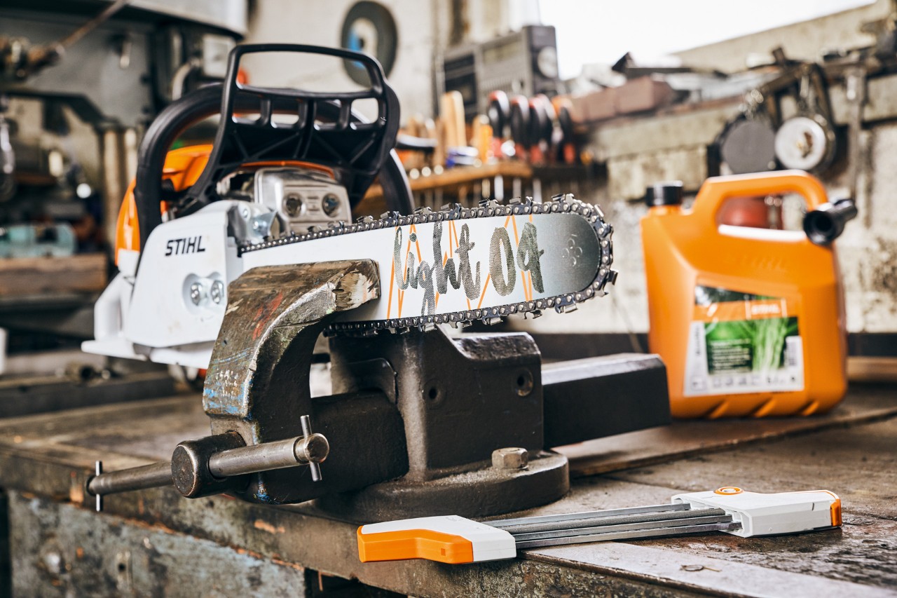 STIHL MS 261 C-M bensinmotorsag med Light 04 sverd ved siden av STIHL MotoMix drivstoffblanding før sliping