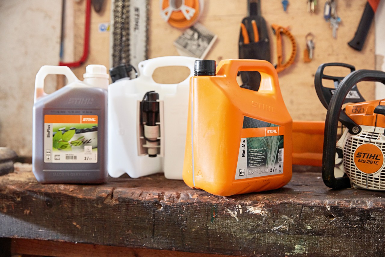 Kanne med STIHL MotoMix motorsagblanding, olje og bensin og en STIHL MS 261 C bensinmotorsag i et verksted