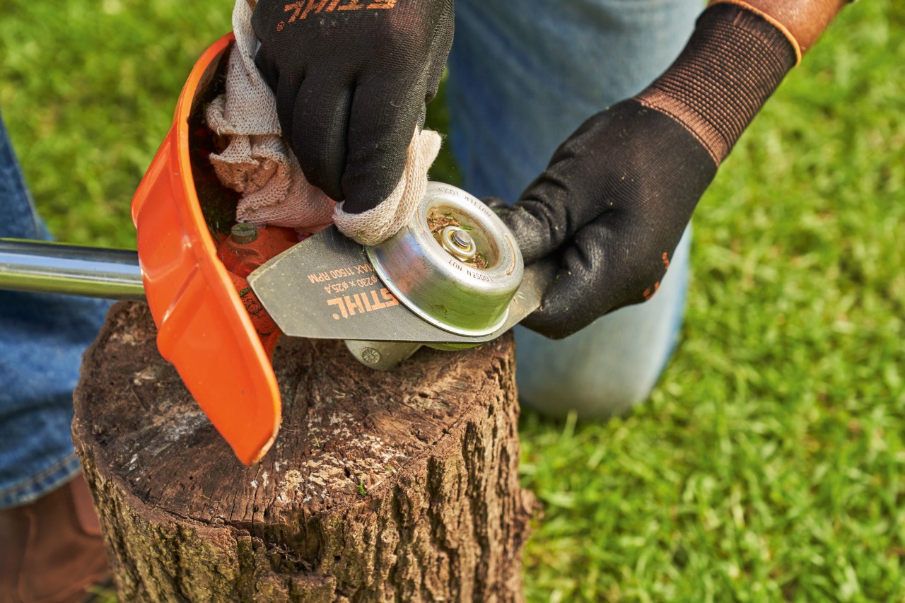 Rengjøre en krattkniv på en STIHL ryddesag med en fuktig klut