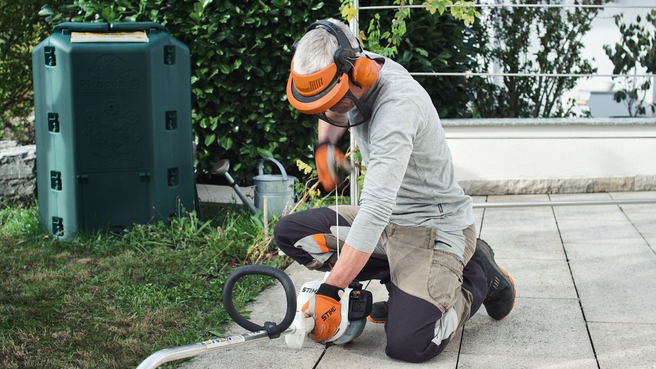 En person med verneklær trekker i startsnoren til en STIHL FS 38 bensindrevet ryddesag