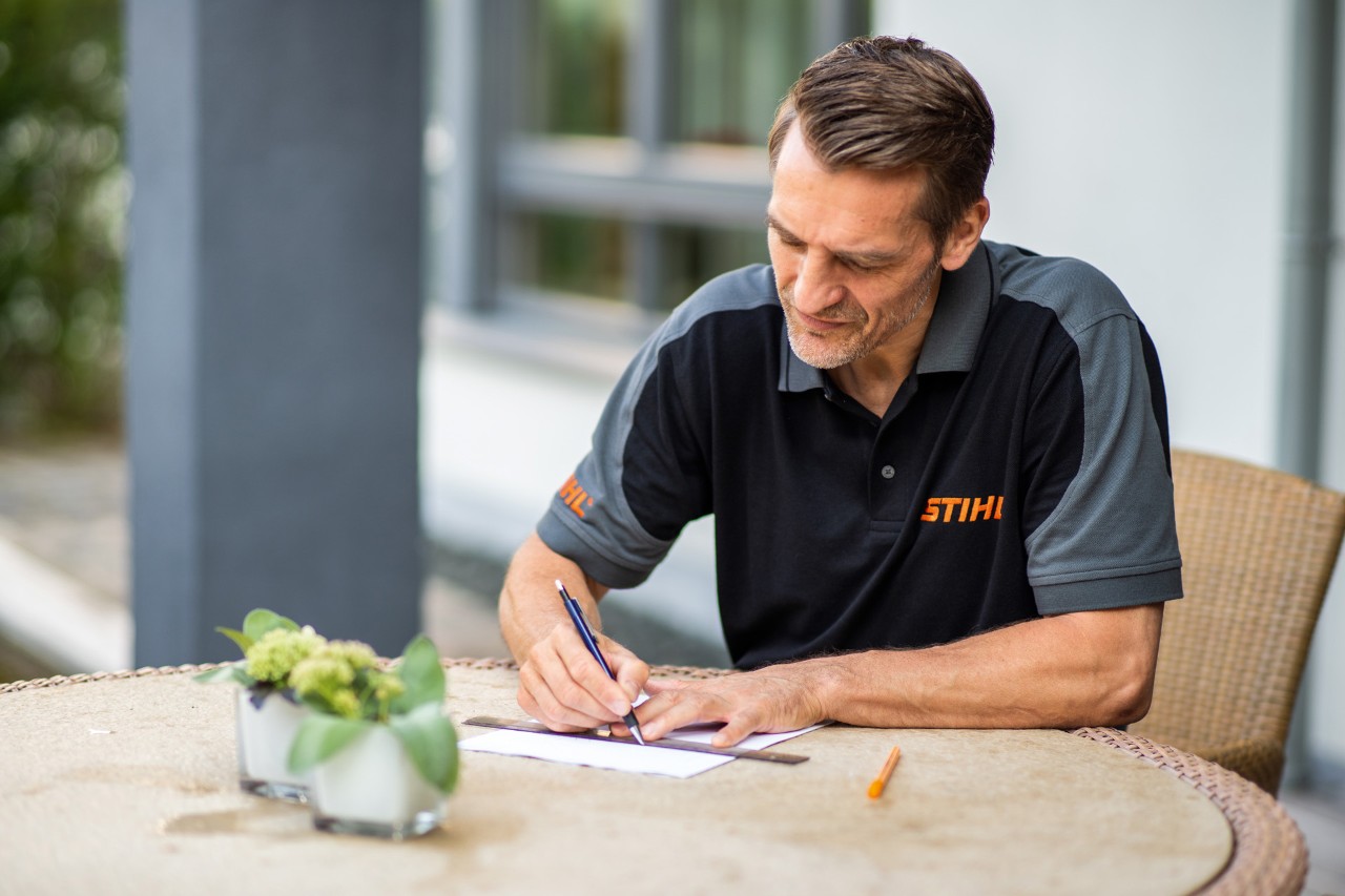En STIHL-forhandler skisserer et klippeområde for en STIHL iMOW® 422 robotgressklipper