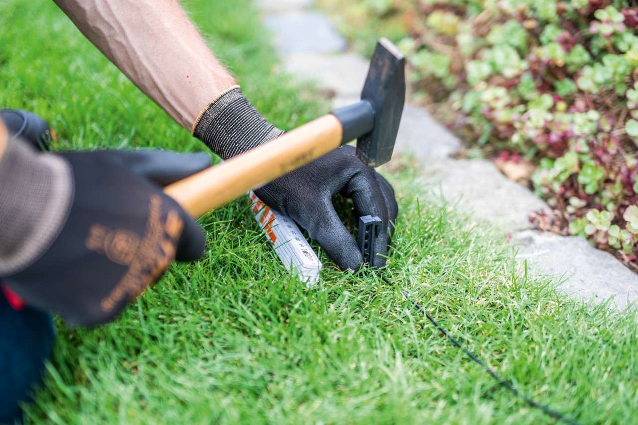 Avgrensingstråd for en STIHL iMOW® 422 robotgressklipper installert langs kanten av en plen