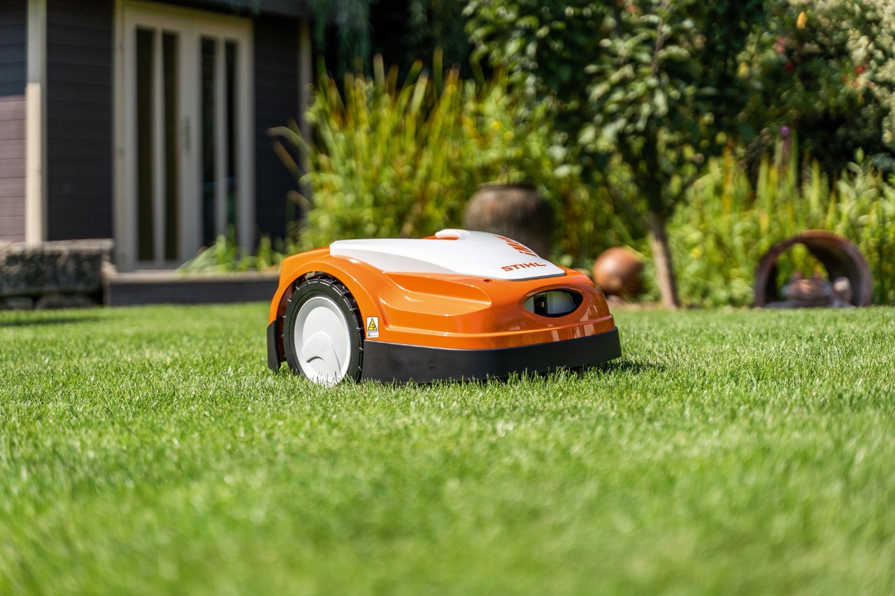 En STIHL iMOW® RMI 422 robotgressklipper på en gressplen foran et hus